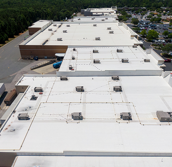 Aerial view of expansive industrial warehouse rooftops with cooling units.